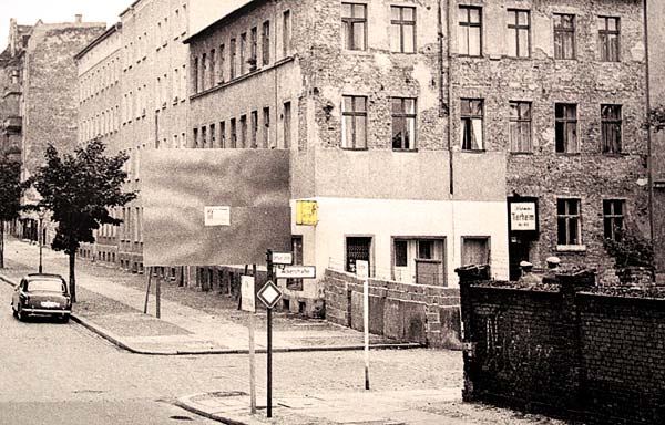 Этот дом стоял в Восточном Берлине, а окна выходили на Запад. Люди убегали через окна, а западники специально установили рекламный щит, чтобы этого не видели пограничники