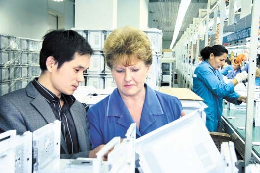 Специалист из Китая, ведущий инженер-технолог Юй Ху и контролер Наталья Елошина осматривают подготовленные к сборке детали печки