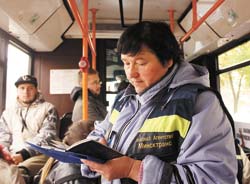 контролер пишет в книжке в автобусе