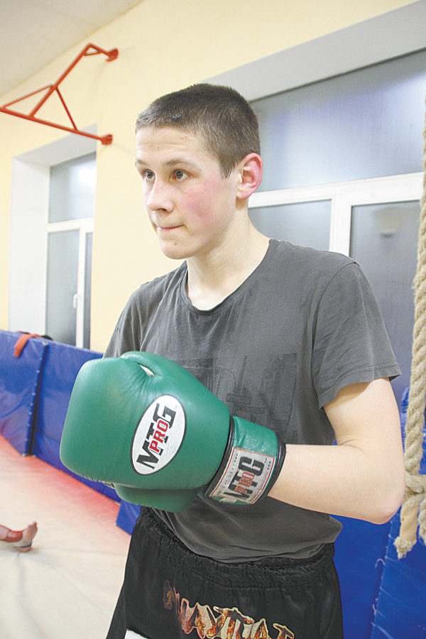 юный спортсмен на тренировке по тайскому боксу