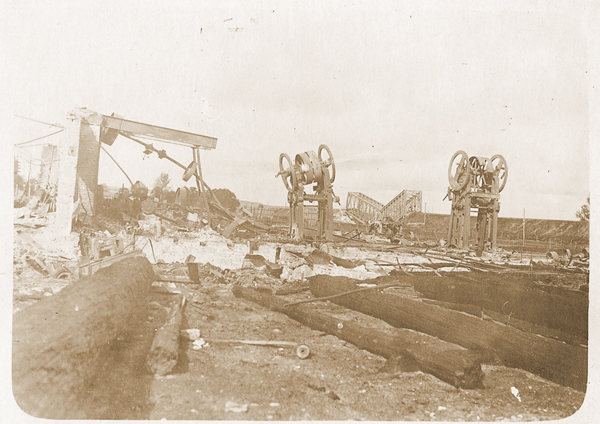 подожженная лесопилка на фоне разрушенного моста Эйфеля